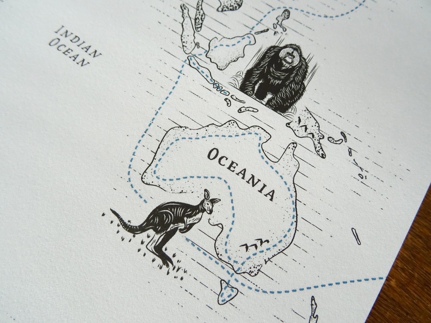 Close-up on the right page of the book with a focus on Oceania with an illustrated Orangutan and a kangaroo
